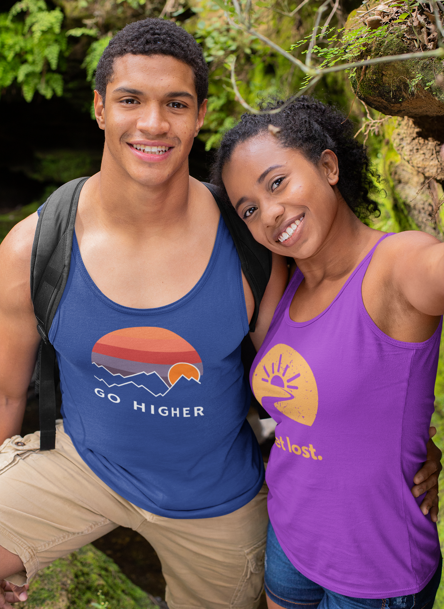 A couple wearing tank tops that have stopped to take a break on their hike. The girl is taking a selfie of the couple.